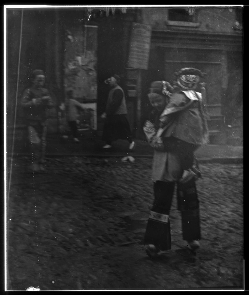 Woman carrying a child crossing a street, Chinatown, San Francisco LOC agc.7a55041