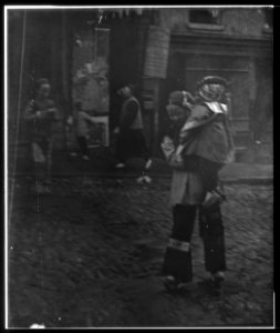 Woman carrying a child crossing a street, Chinatown, San Francisco LOC agc.7a55041
