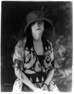 Woman modeling dress and hat, half-length portrait, seated LCCN89710488