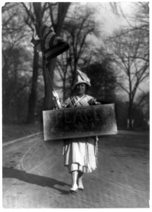 Woman marching with peace sign and U.S. flag, disarmament conference, Washington, D.C. LCCN89713568