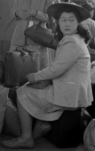 Woman sitting in suitcase detail, Woodland, California. Families of Japanese ancestry with their baggage at railroad station awaiting . . . - NARA - 537804 (cropped)