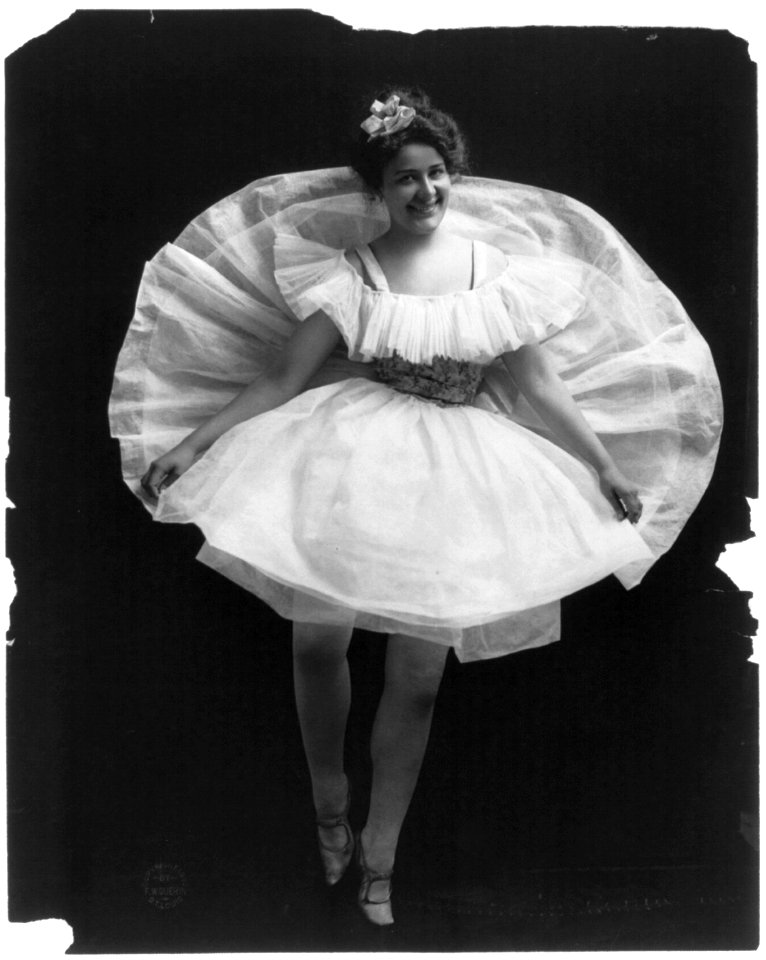 Woman posed, full-length, standing, facing front, wearing ballet costume, with back of skirt raised behind her LCCN96506056