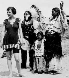 Woman in swimsuit on beach with an Indian family in 1923- LCCN99471588 (cropped)