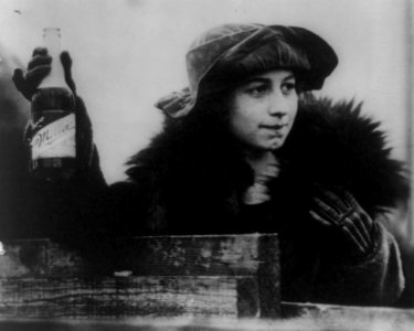 Woman with a bottle of Miller Beer in 1921 detail, from- Zion City, Ill., destroys 80,000 pint bottles of beer LCCN88715933 (cropped)