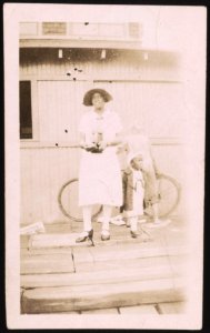 Woman, holding camera, standing on steps with a child LCCN2015650136