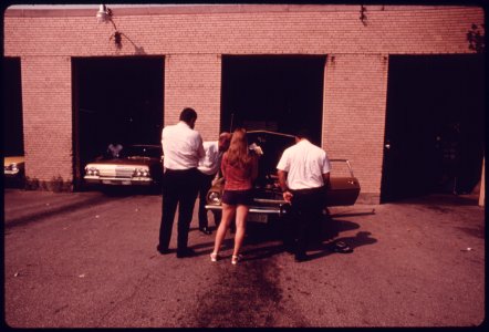 Woman, Center, Is Having Minor Adjustments Made to Her Auto's Carburetor During Retesting after Her Vehicle Had Failed at an Auto Emission Inspection Station in Downtown Cincinnati, Ohio...09-1975 (4265796349)