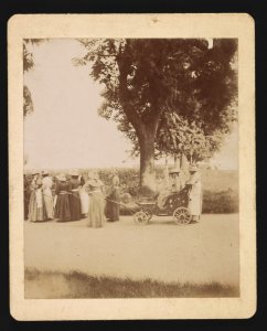 Women walking in a procession, pulling a wheelchair LCCN2015645628