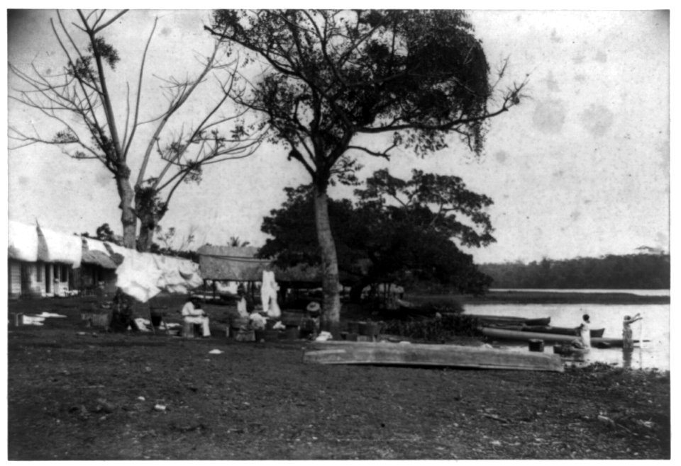 Women washing clothes in river and sitting outside dwellings in Greytown, Nicaragua LCCN89714822