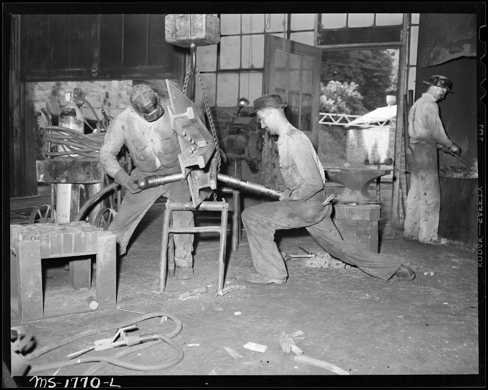 Woodrow Lamb (left) and Cyrus Williams rivet a railroad frag onto a bedplate in machine shop at the mine. Koppers... - NARA - 540924