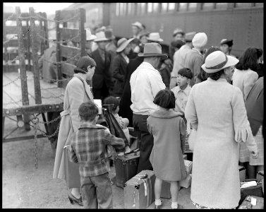 Woodland, California. Farm families of Japanese ancestry waiting at the railroad station for the sp . . . - NARA - 537809 photo