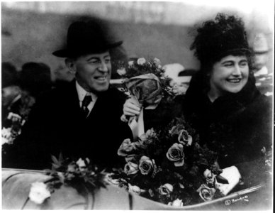 Woodrow Wilson, half length, seated, facing right; and his wife (Edith Bolling Galt) holding flowers LCCN2006690217