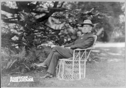 Woodrow Wilson, full, seated in wicker chair on lawn of Prospect, his home at Princeton, N.J., facing left LCCN2007678232