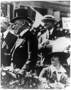 Woodrow Wilson, in a top hat, standing while his wife Edith Bolling Galt looks on LCCN2013648780
