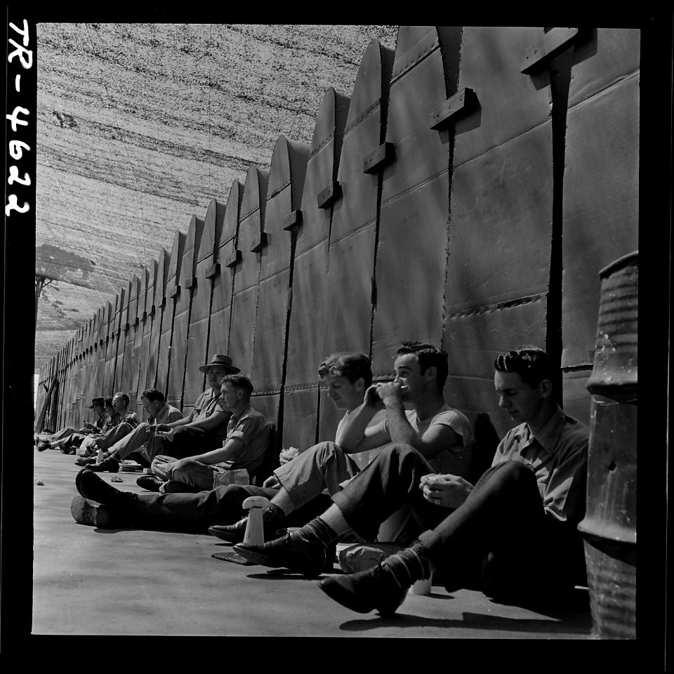 Workers eat lunch against PBY wing panels at Consolidated Vultee aircraft plant, San Diego, Cal. - NARA - 520980