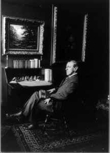 Woodrow Wilson, full length, seated by desk with book in hand, facing left LCCN2005684885 photo