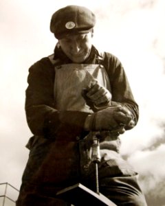 Worker uses tools to fit coamings to machine-gun wings on submarine chaser, 1942 (27863336306)