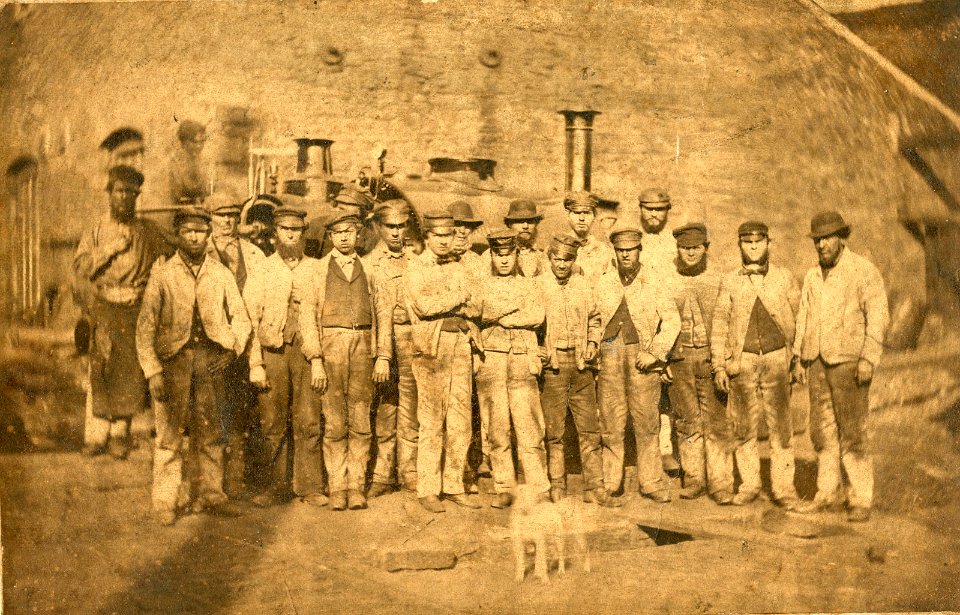 Workers at Neath Abbey Ironworks in front of steam locomotive, probably 'The Plymouth', ca 1870 (Neath Abbey Archives)