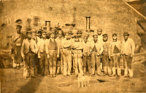 Workers at Neath Abbey Ironworks in front of steam locomotive, probably 'The Plymouth', ca 1870 (Neath Abbey Archives)
