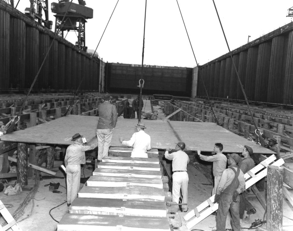 Workmen lay the keel plate of USS United States (CVA-58) on 18th April 1948