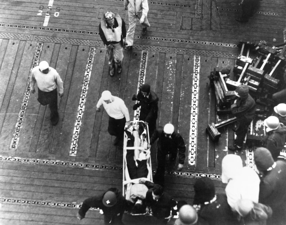 Wounded airman is carried across the flight deck of USS Enterprise (CV-6) on 4 June 1942 (80-G-7745)