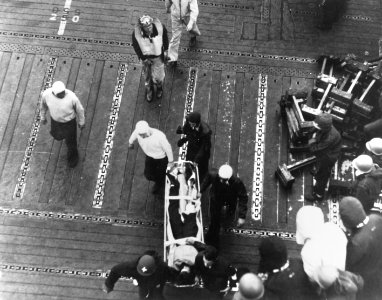 Wounded airman is carried across the flight deck of USS Enterprise (CV-6) on 4 June 1942 (80-G-7745)
