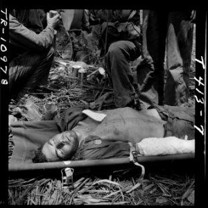 Wounded Pfc. Robison in stretcher on Guam after receiving blood plasma. - NARA - 520950