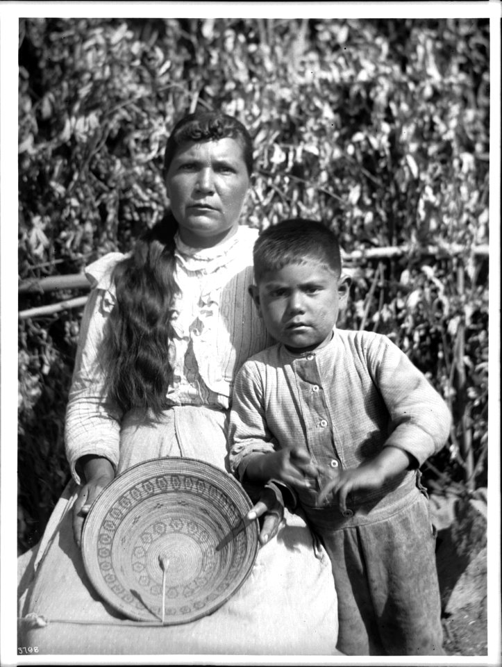 Yokut Indian women basket maker and her son home from school, Tule River Reservation near Porterville, California, ca.1900 (CHS-3798)