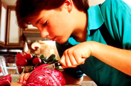 Young boy slicing cabbage