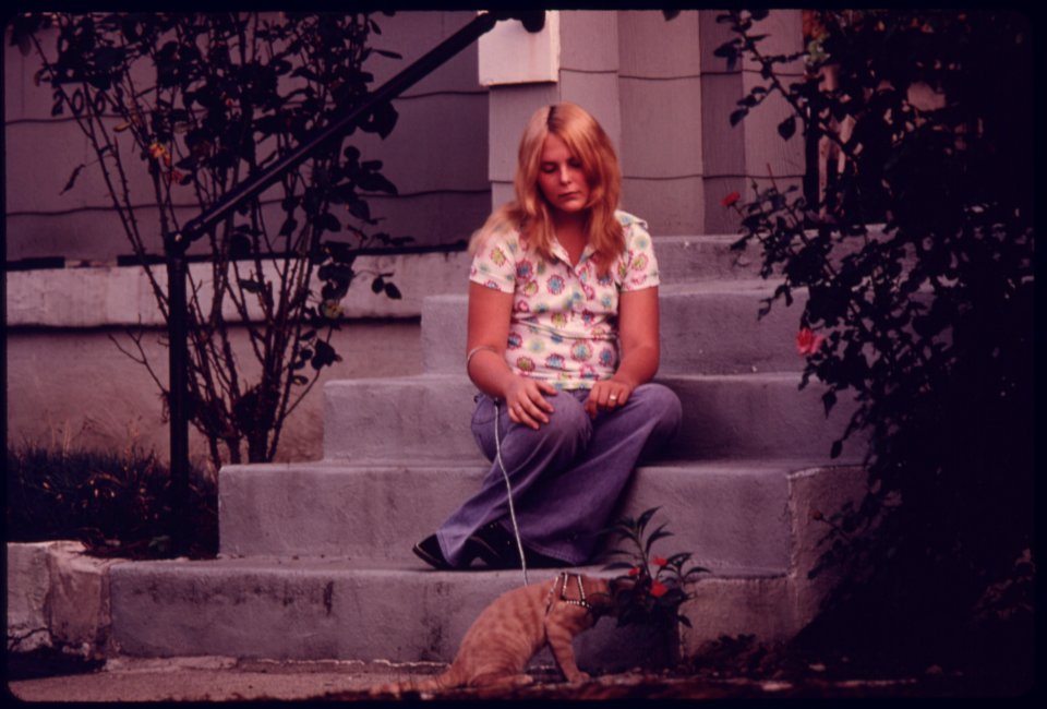 Young Girl Sits on the Porch Steps Daydreaming While Her Cat Sniffs Flowers...09-1975 (4265778807)