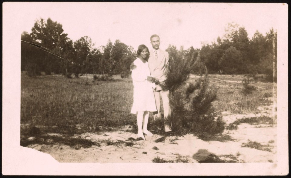 Young couple standing in a field, the man with right arm around the woman's shoulder LCCN2015650129
