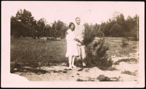 Young couple standing in a field, the man with right arm around the woman's shoulder LCCN2015650129