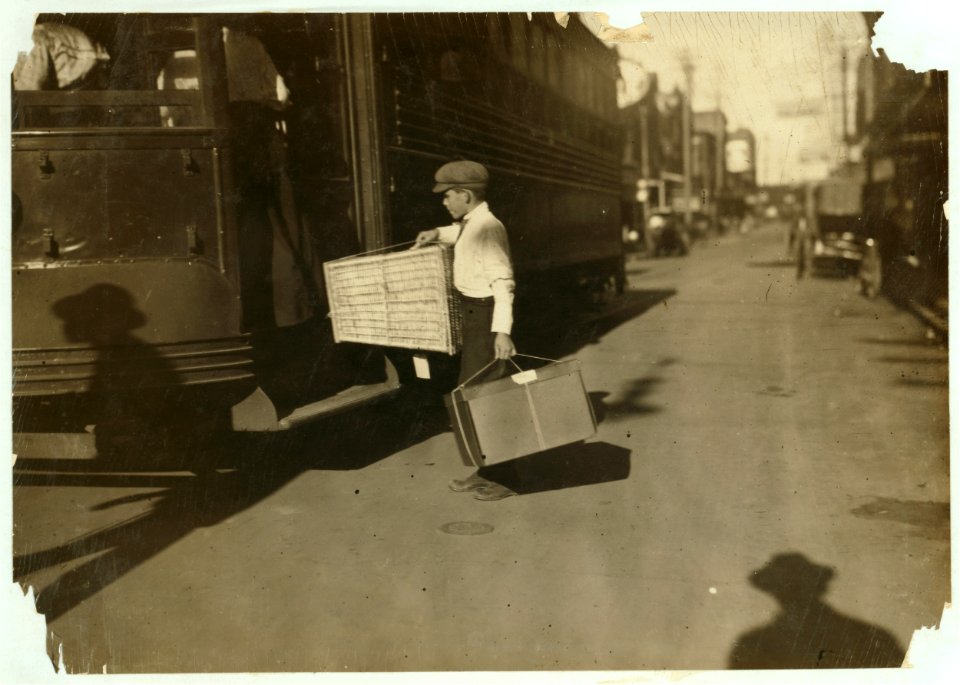Young delivery boy with heavy bundles. LOC nclc.03952