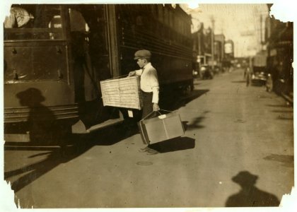 Young delivery boy with heavy bundles. LOC nclc.03952