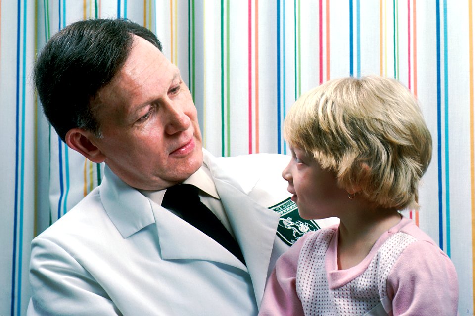 Young girl sits on doctor's lap