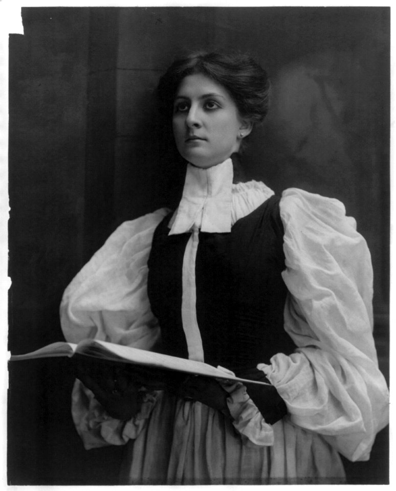 Young woman modeling- half lgth., standing in choir robe, holding open music book LCCN2003677228