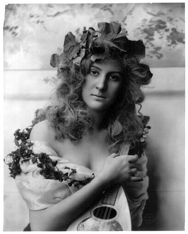 Young woman modeling- Half lgth., vines on head around shoulders, holding mandolin LCCN2003677222