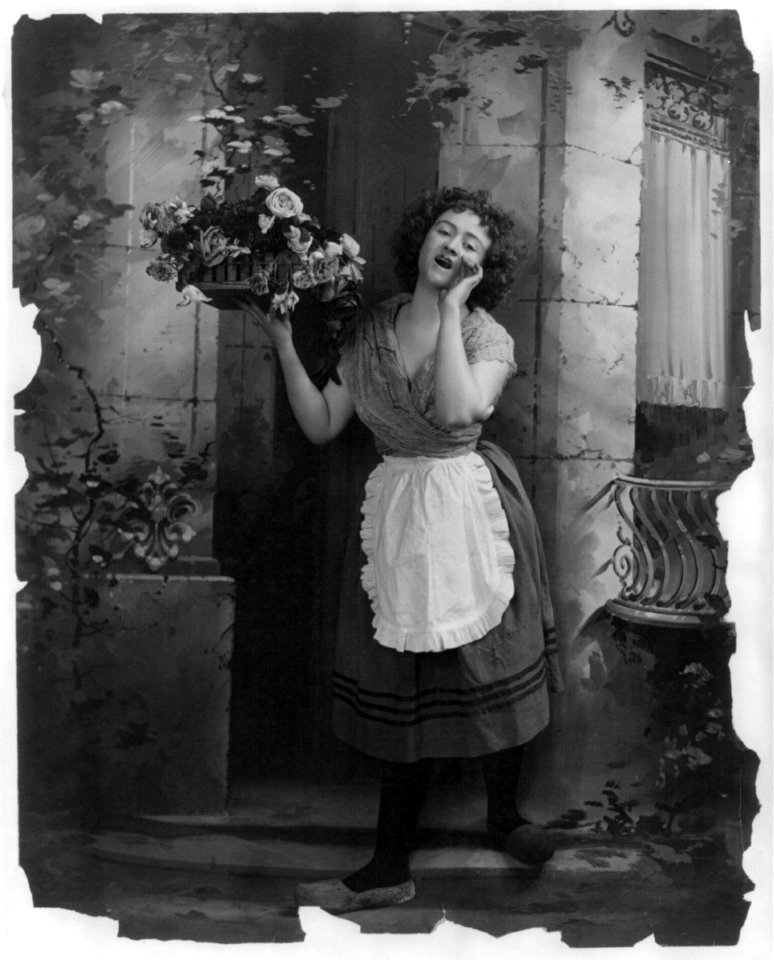 Young woman modeling- Full lgth., standing, wearing Dutch costume and hawking tray of flowers LCCN2003677245