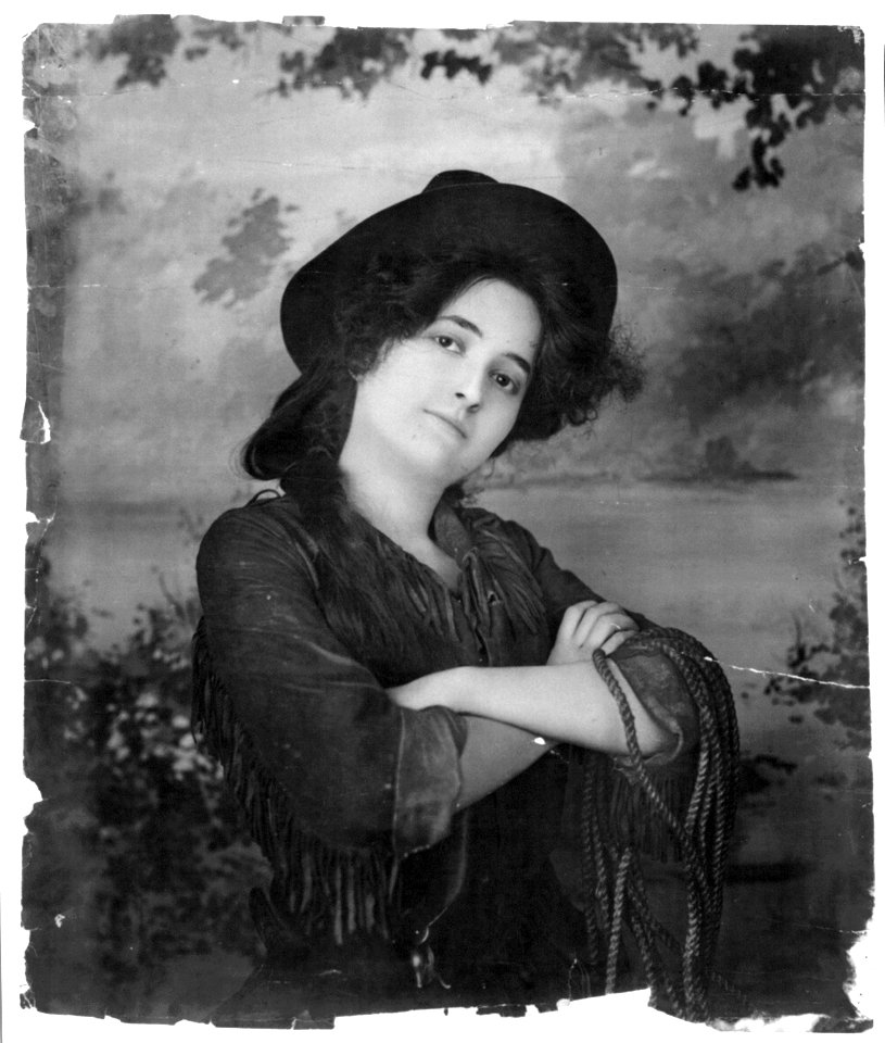 Young woman modeling- Half lgth., wearing cowgirl outfit and holding rope LCCN2003677230