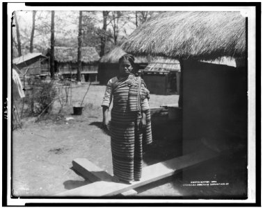 Young woman in traditional clothing, smoking pipe, in Igorot village of Louisiana Purchase Exposition LCCN95502540
