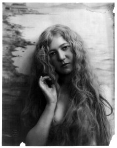 Young woman modeling- Head and shoulders, with very long hair, right hand raised toward head LCCN2003677221