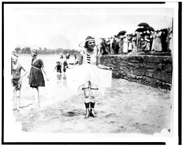 Young woman posing in bathing suit with other bathers and spectators in background LCCN92522661