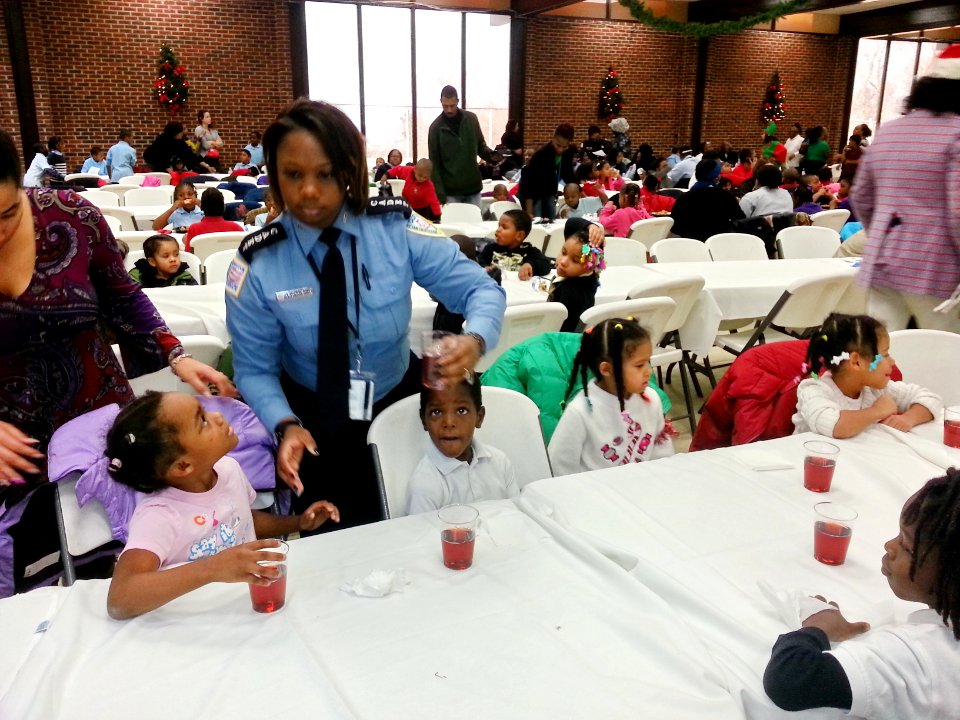Youth at the DC Ward 8-Metropolitan Police Department (MPD) Seventh District holiday party for underprivileged children look up to a Cadet from the MPD Police Academy 131218-N-CG900-006