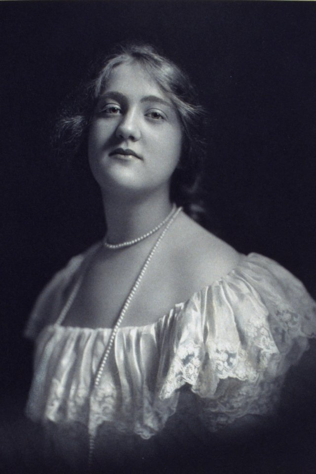 Young woman wearing an off-the-shoulder dress and long pearl necklace, looking front, head-and-shoulders portrait LCCN2004676399 (cropped)