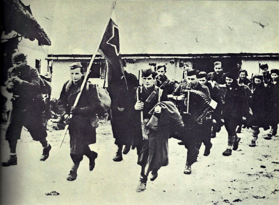 Zastavonoša Šercerjeve brigade Jože Zabukovec na čelu brigade 10. januarja 1944 na pohodu skozi vas Sv. Jane