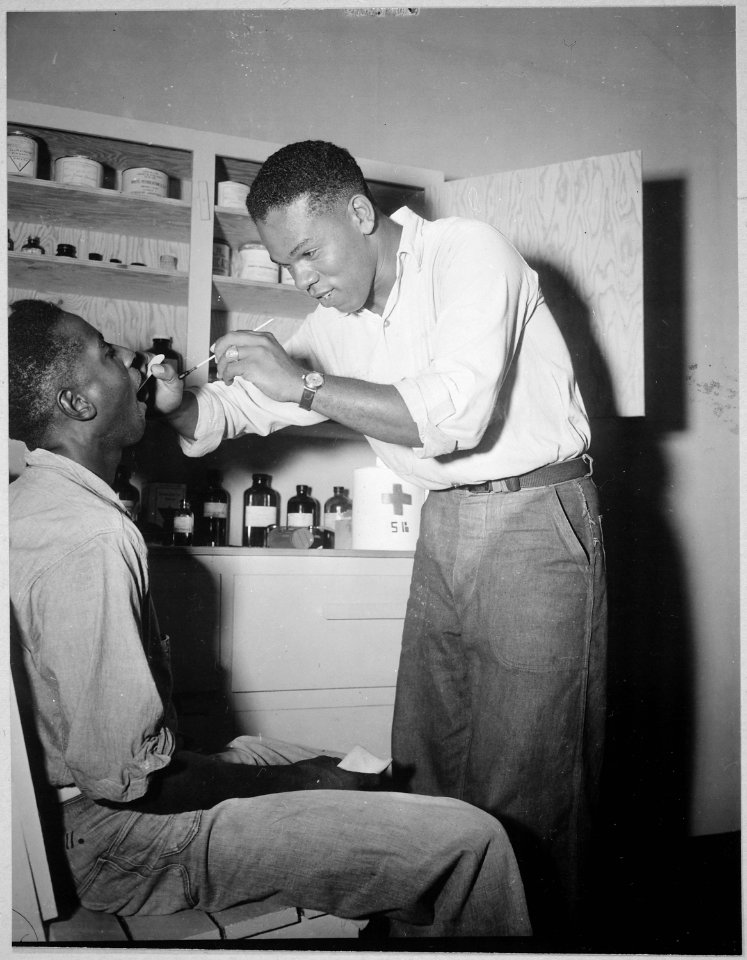A dispensary at a Naval ammunition depot in the Marianas. Prevention against a case of sore throat. Patient-Dan Kenne - NARA - 520684