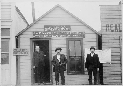 Claims bought and sold. U.S. Land Office practice-contests a specialty. Attorneys and surveyors in front of office, w - NARA - 540091