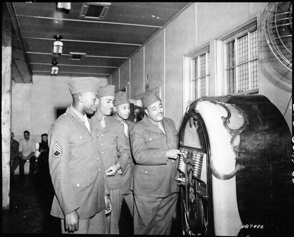 First of the famous Mills Brothers quartet to enter Army service, Pvt. Harry Mills stops at the jukebox in the Receptio - NARA - 531178
