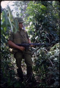 Doe Morris moves through heavy grass in a deserted rice paddy while on patrol during operation Kentucky V with A... - NARA - 532455