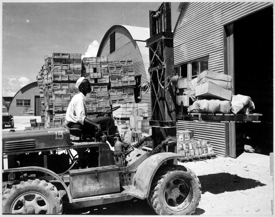 M. D. Shore, S1-c, operating a forklift truck at the Navy supply depot at Guam, Marianas., 06-08-1945 - NARA - 520685