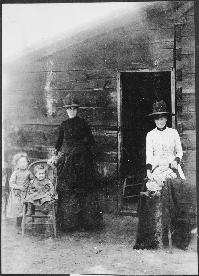 Mormons at Mormon Dairy. DESCR= Two women and their small children pose before a building at what is now known as Morm - NARA - 523552